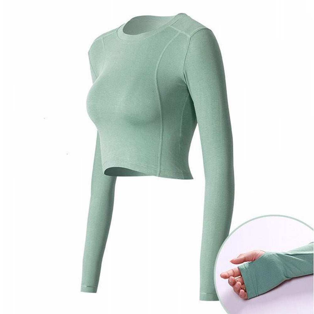 Long-sleeve active crop top with thumbholes in light green color, designed for comfort and versatility.