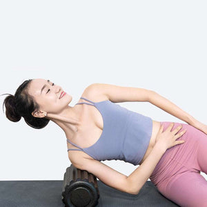 Woman using Basic Fitness Roller for muscle recovery.