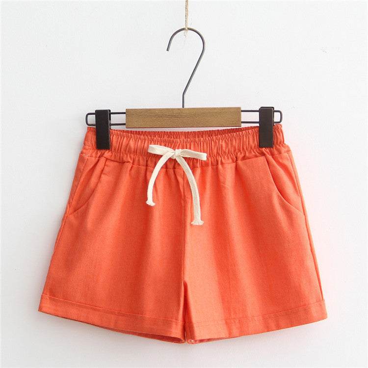 Orange comfy shorts with adjustable drawstring waist, soft breathable cotton fabric, and side pockets.