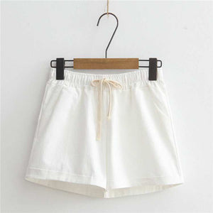 White comfy shorts with adjustable drawstring waist hanging on a hanger.