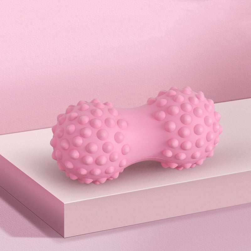 Pink textured peanut-shaped massage ball for muscle relief and relaxation.