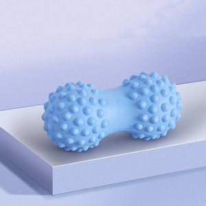 Blue textured peanut-shaped massage ball on a white platform for muscle relief.