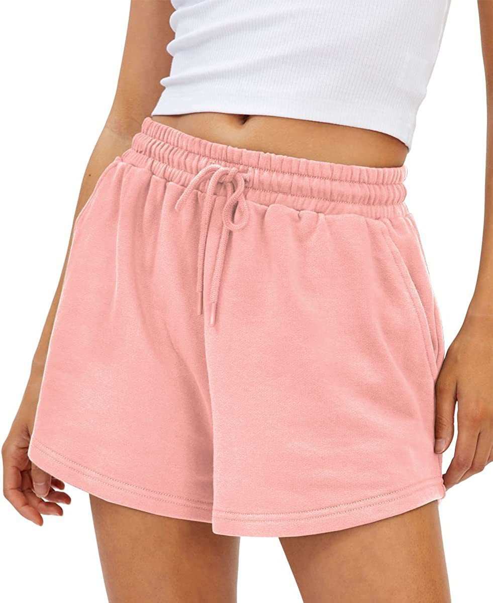 Woman wearing pink loose fit shorts with drawstring waistband.