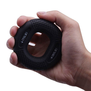 Hand holding a black silicone grip ring designed for grip training and hand workouts with customizable resistance levels.