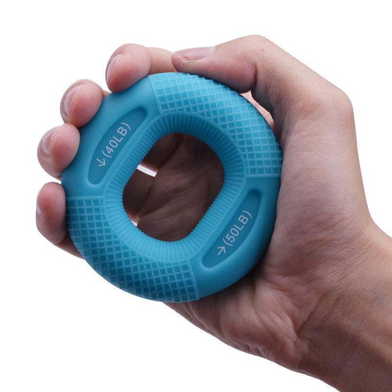 Blue silicone grip ring held in hand for strength training, featuring resistance levels indicated on the surface.