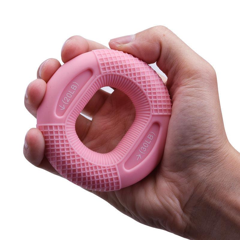 Pink silicone grip ring for hand strength training in use.