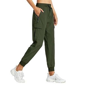 Olive green snug fit pants with adjustable waistband and zipper pocket, styled with white sneakers.