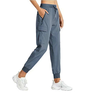 Women's snug fit pants in gray, featuring adjustable waistband and multiple pockets, designed for comfort and versatility.