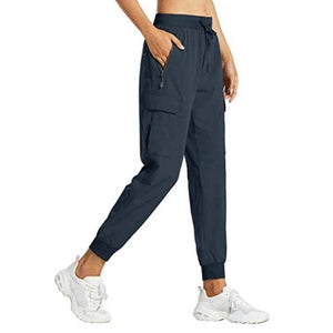 Woman wearing black snug fit pants with adjustable waistband and pockets.