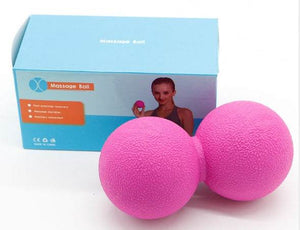 Pink peanut-shaped massage ball with packaging in the background.