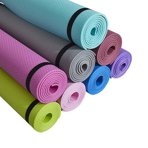 Stack of colorful non-slip yoga mats with honeycomb design.